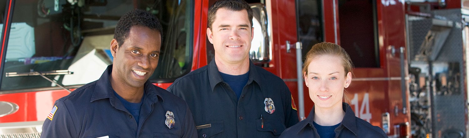 Firefighters standing beside a fire engine